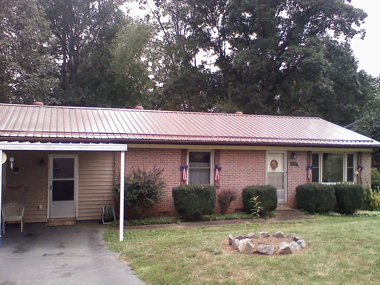 Bronze metal roof and carport on a brick ranch home — Roof Repair work by our crew in Sparta